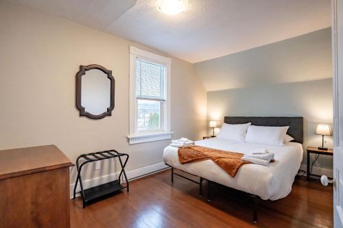 a bedroom with a large bed and a mirror at Downtown Heritage Home W/ Hot Tub 509 Mackenzie in Revelstoke