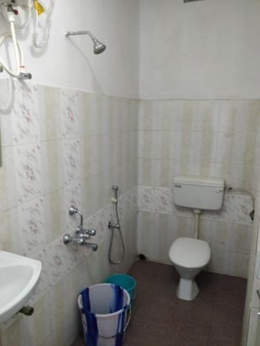 a small bathroom with a toilet and a sink at Adarsh Hotel in Port Blair
