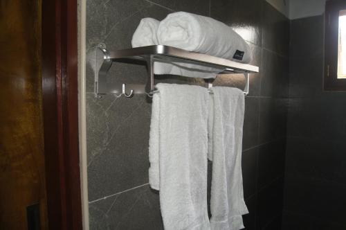 a towel rack in a bathroom with white towels at Blue Cactus Shanty in Moshi