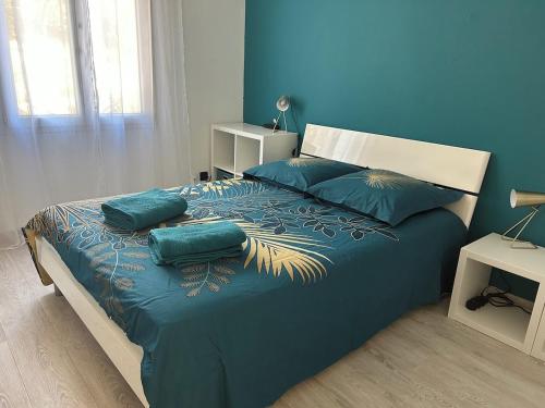 a blue bedroom with a bed with blue sheets and pillows at VILLA AVEC PISCINE in Néoules