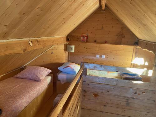 a large wooden cabin with two beds in it at Les Cabanes de Maya in Caille
