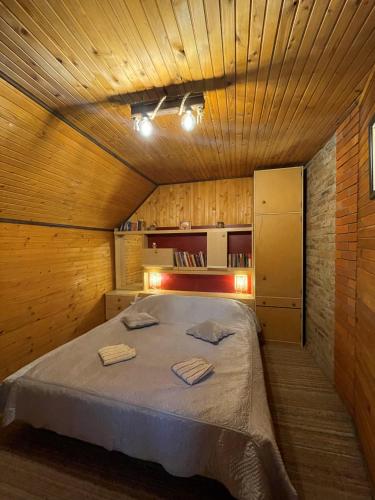 a bedroom with a large bed in a wooden room at Kućica za odmor '' Idila '' in Mitrovac