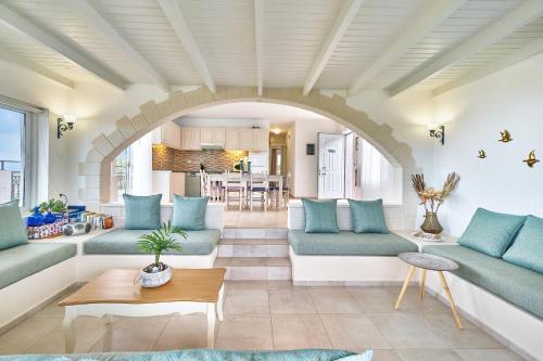 a living room with blue furniture and an archway at Pano Stalos Villas in Stalos