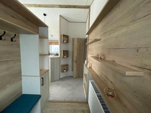 a room with wood paneling and a staircase in a house at Rye Harbour Holiday Park in Rye Harbour