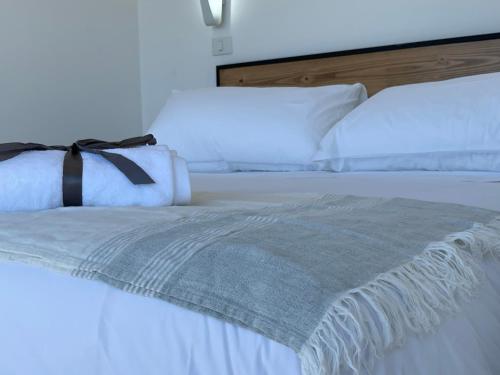 a white bed with a black ribbon on it at Loft Increíble Vista y Jacuzzi Gratis, Único - 2A in Navidad