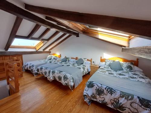 two beds in a room with skylights at La Corralada de Merón in San Vicente de la Barquera