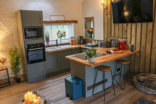 a kitchen with a counter with a sink and a stove at Tanyard Barn - Luxury Hot Tub & Secure Dog Field Included in Old Glossop