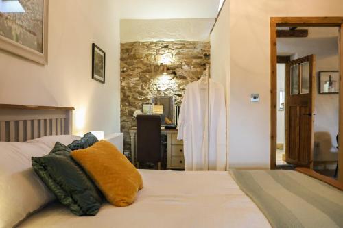 a bedroom with a bed and a stone wall at Tanyard Barn - Luxury Hot Tub & Secure Dog Field Included in Old Glossop
