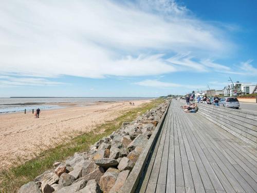 a boardwalk on a beach with people and the ocean at 2 person holiday home in Esbjerg V in Esbjerg