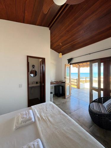 a bedroom with a bed and a view of the ocean at Pousada Villa Sagi in Baía Formosa
