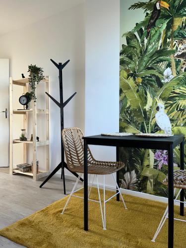 a black table and a chair in a room at Studio tropical , vierzon , proche gare , tout confort in Vierzon