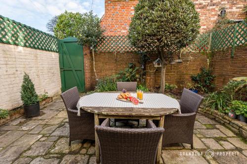 a table with a plate of fruit on top of it at Stylish townhouse, Poole Quay, sleeps 6, garden - Gull House in Poole