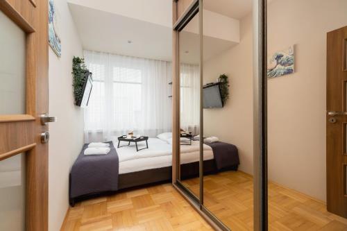 a bedroom with two beds and a glass door at Łagiewniki Sanctuary One Bedroom Apartment by Renters in Krakow