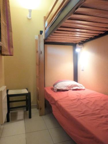 - une chambre avec des lits superposés et une couette rouge dans l'établissement GASQUEN - Golfe de St-Tropez - Aux Marines de Gassin Duplex pour 7 personnes, à Gassin