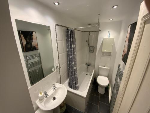 a bathroom with a sink and a toilet and a shower at Stunning 1-Bed Apartment in Aberdeen city centre in Aberdeen
