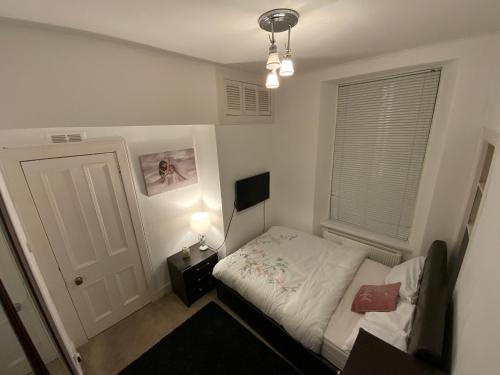 ein kleines Schlafzimmer mit einem Bett und einem Fenster in der Unterkunft Stunning 1-Bed Apartment in Aberdeen city centre in Aberdeen