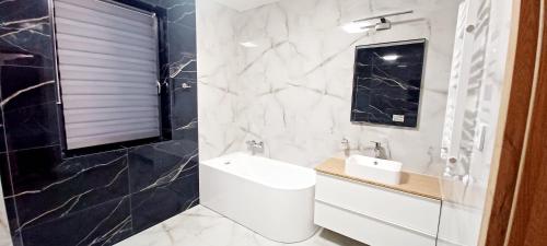 a bathroom with a sink and a toilet and a mirror at AJP Prestige House Szczecin Załom in Szczecin
