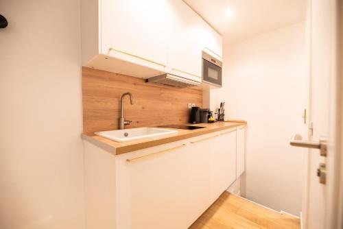 une petite cuisine avec un évier et un comptoir dans l'établissement Cosy Nest in Saint Germain, à Paris
