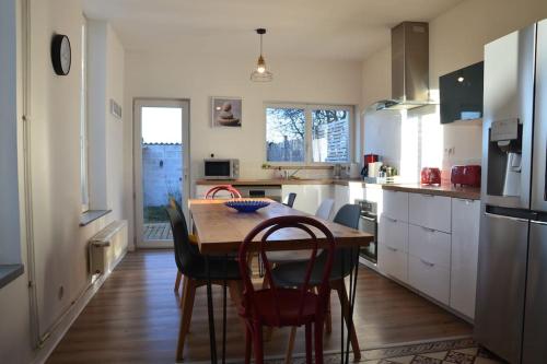 une cuisine avec une table en bois et quelques chaises dans l'établissement Grande maison idéalement située: Les Arômes, à Wimereux