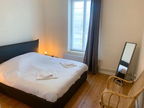 une chambre avec un lit avec deux serviettes dessus dans l'établissement Grande maison idéalement située: Les Arômes, à Wimereux