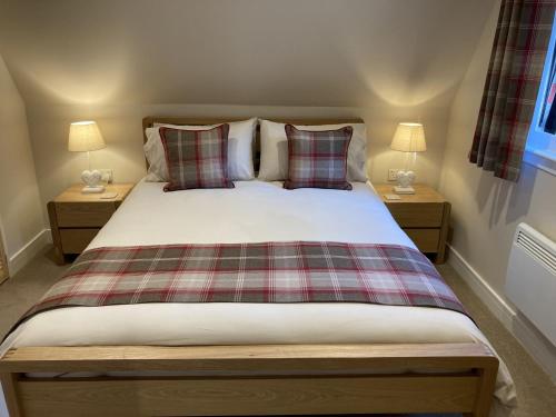 a bedroom with a bed with two lamps on tables at Lodge 24 in Spean Bridge