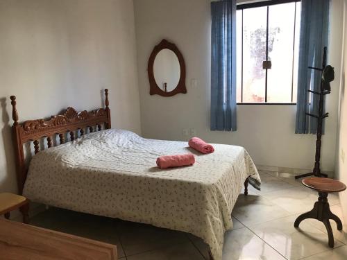 - une chambre avec un lit et 2 serviettes roses dans l'établissement Casa no Centro de Piumhi, à Piuí