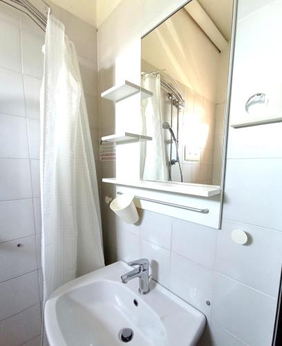 a white bathroom with a sink and a mirror at Villa Gioiosa Beach & Water Park B&B in Rimini