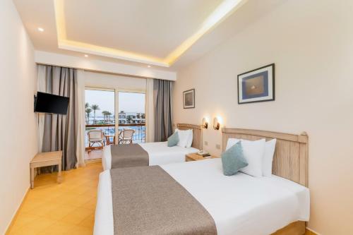 Habitación de hotel con 2 camas y balcón en Sunrise Alma Bay Resort, en Hurghada