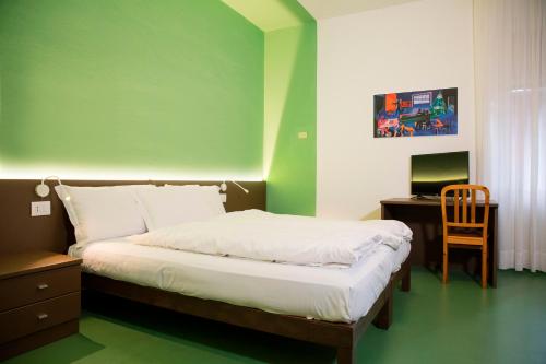 a bedroom with a bed with a desk and a chair at Hotel Villa Flora in Roncegno