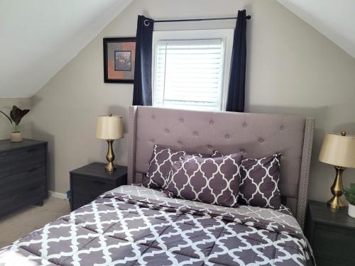 a bedroom with a bed with a purple headboard and a window at Brand new house with private bath in each room in West Seneca