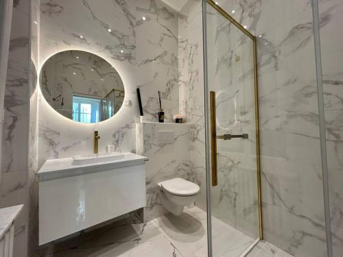 La salle de bains blanche est pourvue de toilettes et d'un miroir. dans l'établissement Charme et Volupté à République, à Paris