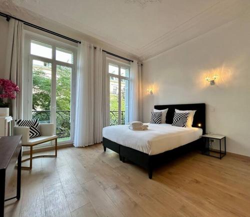 une chambre avec un grand lit et une grande fenêtre dans l'établissement Charme et Volupté à République, à Paris