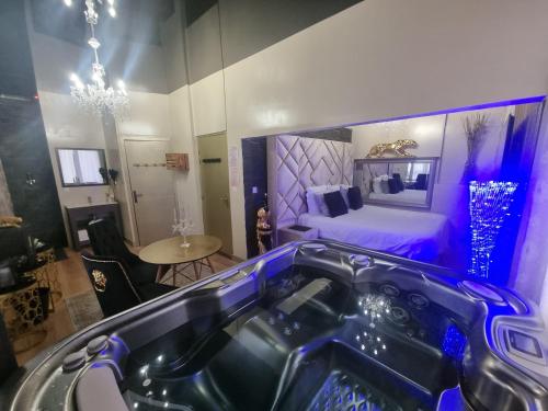 een kamer met een bad en een slaapkamer met een bed bij Les Spa de Venus suites avec jacuzzi spa privatif in Charavines