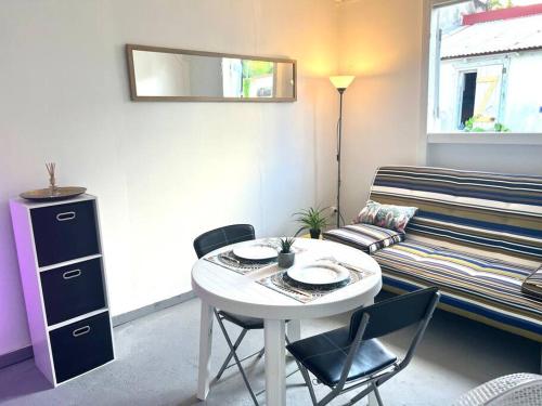 Habitación con mesa, sillas y sofá en Bonheur en Centre-Ville : Réservez votre Évasion F2 à Basse-Terre, en Basse-Terre