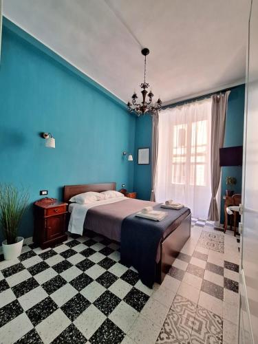 um quarto com uma cama com paredes azuis e um piso em xadrez em The Painter's House em Roma