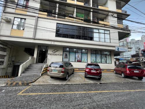 2 voitures garées sur un parking en face d'un immeuble dans l'établissement Buenbyahe Rooms Studio Type Mandaluyong Edsa Shaw MRT Studio at F Residences Under new management, à Manille