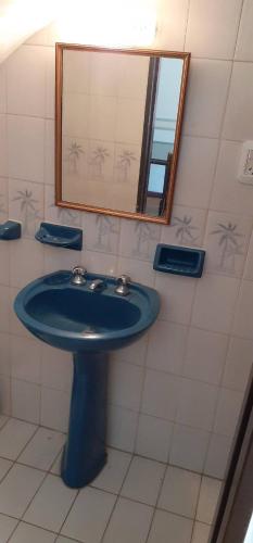 uma casa de banho com um lavatório azul e um espelho. em Santa Teresita Alquila Duplex em Santa Teresita