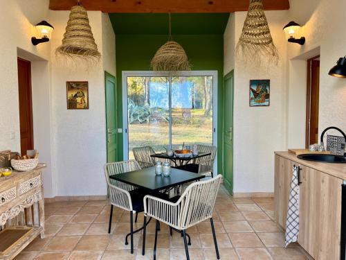 a dining room with a table and chairs in a kitchen at Au Bonheur Dezange in Pézenas
