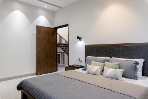 a bedroom with a large bed with pillows at Villa Olives, Vanashraya in Jaipur