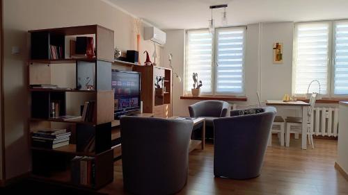 a living room with a table and chairs and a television at Apartament Nadstawna klimatyzowany in Biłgoraj