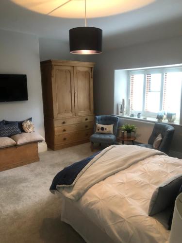 a bedroom with a bed and a tv and a couch at The Skreen in Builth Wells