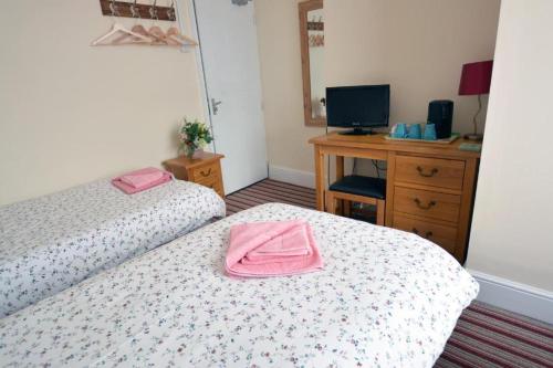 two pink towels on two beds in a room at ALARA Bed and Breakfast in Sheffield