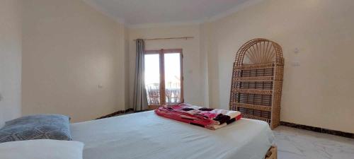 a bedroom with a bed and a large window at Green Beach Camp & Hotel in Nuweiba