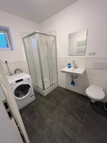 a bathroom with a washing machine and a sink at Rona 2xZimmerwohnung in Darmstadt