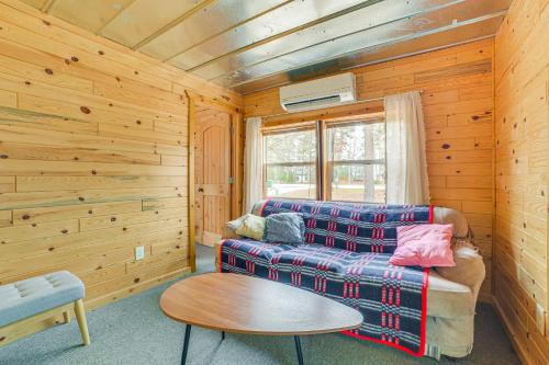 a living room with a couch and a table at Oscoda Cabin with Charcoal Grill Walk to Lake Huron in Oscoda