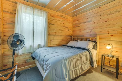 a bedroom with a bed in a log cabin at Oscoda Cabin with Charcoal Grill Walk to Lake Huron in Oscoda