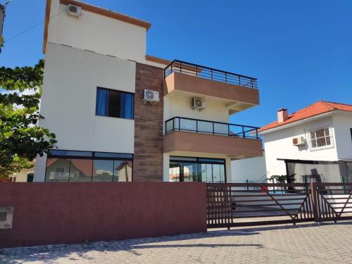 ein Gebäude mit einem Zaun davor in der Unterkunft Pousada Nova Trilha in Palhoça
