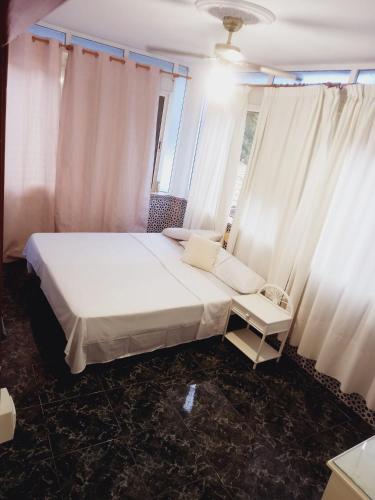 1 dormitorio con cama blanca y ventana en Lounge estrella en Benalmádena