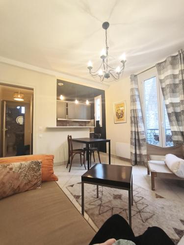 B Appartement في مالاكوف: غرفة معيشة مع أريكة وطاولة