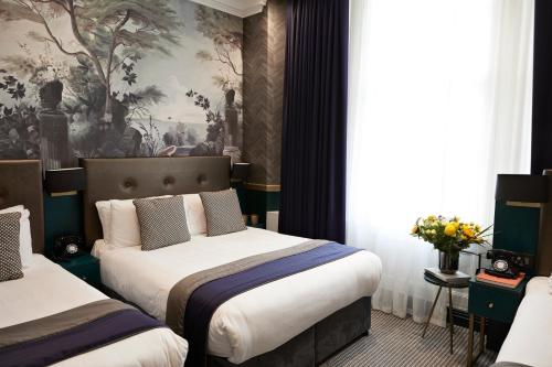 a hotel room with two beds and a mural at The Portico Hotel in London